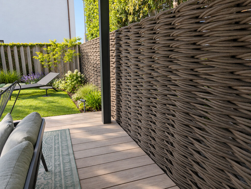 Tressage continu réalisé sur place sans poteaux intermédiaires visibles près d’une terrasse