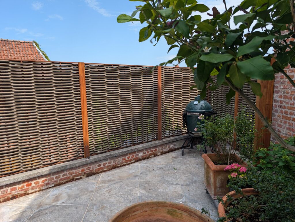 Woodscape panel met tropische hardhout palen en enkele weving met roestkleur kader en bruine houvezel
