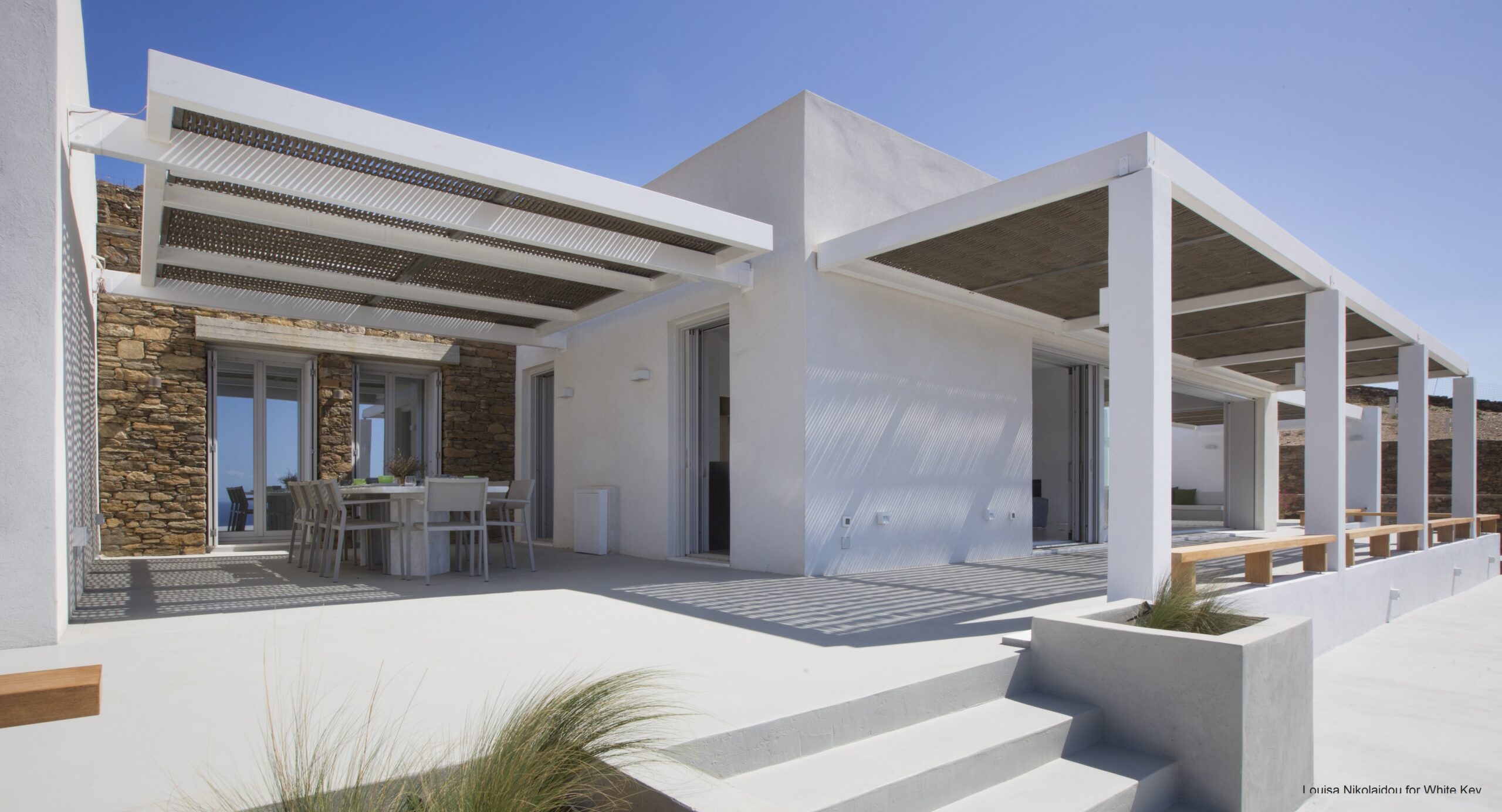 Pérgola Forest Avenue que proporciona sombra junto a una villa moderna