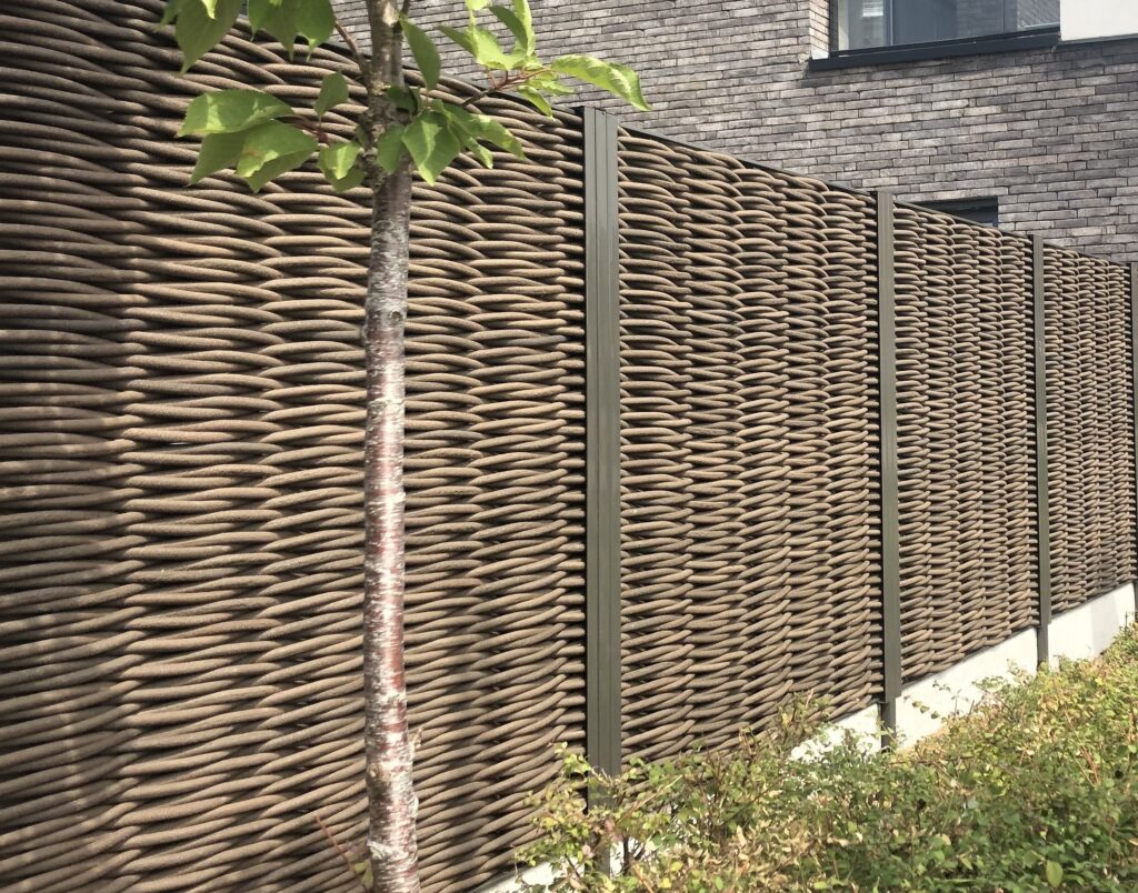 Wooscape panelen met houtvezel bruin vlechtwerk en ombergrijze palen RAL 7022
